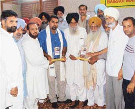 Mr Krishan Kumar Bawa, president, All-India Bairagi Maha Mandal, honours Giani Kewal Singh Nirdosh and Mr Harwant Singh Deol at a function in Ludhiana on Sunday