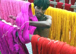 A worker arranges coloured strings on a roof at a hand-dying factory on Sunday.