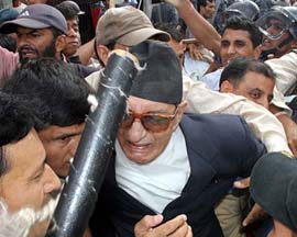 Nepali Congress leader and former Prime Minister Girija Prasad Koirala (centre) grapples with the police while trying to reach a restricted area at New Road in Kathmandu on Sunday.