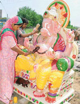 A woman artisan gives final touches to an idol of Lord Ganesha on the eve of Ganesh Chaturthi being celebrated in Ludhiana on Wednesday