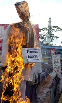 Activists of the Socialist Unity Centre of India shout slogans and burn an effigy of Petroleum Minister Mani Shankar Aiyar at a rally in Kolkata