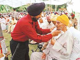 A son of former Sub Gurcharan Dass wipes perspiration from his face
