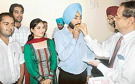 The Vice-Chancellor of Panjab University, Prof K.N. Pathak, offers a ladoo to the student council president, Amandeep Singh, in Chandigarh on Thursday.