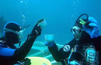 Italian scuba divers Stefano Barbaresi and Stefania Mensa (right) toast their descent while taking part in a scientific experiment aimed at determining the effects of living underwater for a prolonged periods, off the Italian island of Ponza