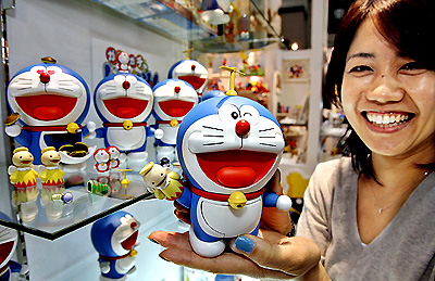Japans toy giant Bandai employee displays a Doraemon doll during the Tokyo International Gift Show on Friday