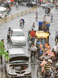 People wade through water as rain lashes Ludhiana on Friday
