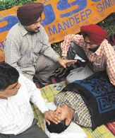 A PU official and PUSU president Amandeep try to convince Nandan, a student of UIET, to go to hospital due to his deteriorating condition, outside the VCs office, PU, Chandigarh, on Sunday. 