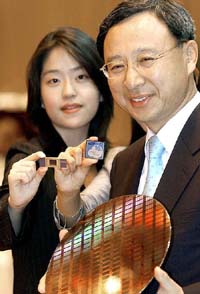 Hwang Chang-Gyu, Samsung Electronics semiconductor business President, and an employee show Samsungs 50-nanometer 16-gigabit NAND flash memory chips in Seoul on Monday. 