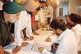 Bidders line up to deposit initial amount at an auction for shops at the Industrial Area, Mohali, on Monday