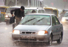 A pedestrian runs for cover as rain lashes the Capital for the second day on Monday bringing considerable relief to Delhiites sweltering under extreme heat and humidity