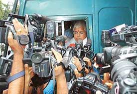 Electronic media persons try to take a sound bite of RJD Chief and Railway Minister Lalu Prasad as he takes to a road show from Patna to Rohtash district in his 'Garib Chetna Rath' to kick off his election campaign in Bihar on Tuesday. 