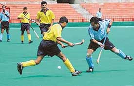 Sukhwinder of the WAC being tackled by a SWAC player during the final of the Air Force Hockey Championship at Sector 42 stadium, Chandigarh