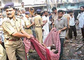 Policemen carry bodies of young children from an explosion at a fire-cracker factory in Khushru Pur village, about 35 km from Patna