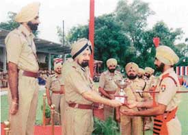 The ADGP-cum-Director, Maharaja Ranjit Singh Punjab Police Academy, Mr Rajdeep Singh Gill, presenting a cup to ASI Lakhbir Singh, who topped the Upper Course