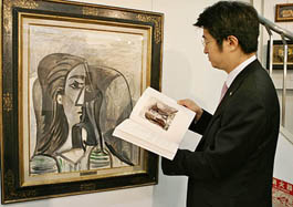 A man checks a Pablo Picassos oil painting, Busta de Femme, at an auction in Tokyo on Friday.