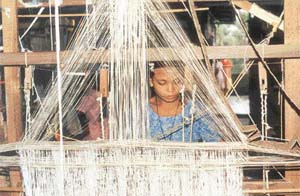 A girl weaves a Muga silk saree
