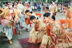Assamese women in the traditional Muga silk saree dance at a festival
