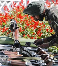 An Army jawan displays arms, ammunation and explosives recovered from militants from Dawar in Gurez sector from a jungle area near the Kishanganga River