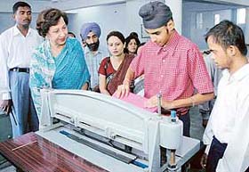 Ms Jean Rodrigues, wife of Punjab Governor, Lt-Gen S.F. Rodrigues, watches a special child make a packet at the Sadhna Vocational Training Institute for the Mentally Handicapped at Mani Majra