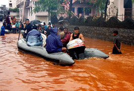 Indian Navy jawans sit in their boat as they move through a flooded street in Visakhapatnam on Wednesday.