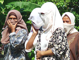 Thai Muslim women and children block the entrance to Tanyong Vimoh village in Narathiwat province, south of Bangkok, on Wednesday where two Thai Marine officers were held captive before being killed. Villagers had accused the officers of being involved in a fatal shooting at a local teahouse the previous day in the violence-plagued region, where 900 people have died in 21 months of separatist unrest.