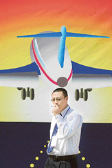 A Chinese visitor walks past a billboard promoting "Aviation Expo China, 2005", in Beijing on Thursday.  The aviation Expo, which features more than 170 exhibitors from 21 countries and region, will run till September 24.  According to industry figures, China will need 2, 500 aircraft in the next 20 years to compliment the explosive demand of tourism and business travellers in the country. 