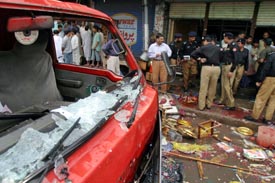 Pakistani poliemen gather at the site of a bomb explosion at a market in Lahore