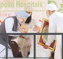 Satguru Jagjit Singh honours Prime Minister Manmohan Singh with a rosary after the inauguration of the Satguru Partap Singh Apollo Hospital in Ludhiana on Friday. 