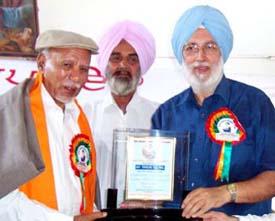 Punjabi University Vice-Chancellor Swaran Singh Boparai gives the Baba Farid Award for Honesty to Tehelka Editor Tarun Tejpals father Inderjit Tejpal in Faridkot on Friday.