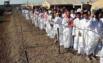 Iraqi detainees stand in line to be processed for release from Abu Ghraib prison