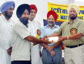 Revenue Minister A.S .Samra and Panjab Agricultural University Vice-Chancellor K. S. Aulakh felicitate a progressive farmer at a kisan mela in Bathinda on Wednesday.