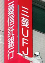Workers replace the old sign with the new Mitsubishi UFJ Trust and Banking Corporation sign in Tokyo. The worlds biggest banking group in terms of assets was launched in Japan on Saturday through the merger of Mitsubishi Tokyo Financial Group Inc and UFJ Holdings Inc. 