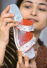 A customer looks at a sandal made of silver at  Lucknow on Sunday. Such sandals with wooden soles are gaining popularity in Lucknow. Nearly 225-300 grams of silver is used on each pair that costs at least  $95.