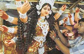An artist from West Bengal gives final touches to an idol of Goddess Durga at Kalibari, near 3 BRD, in Chandigarh