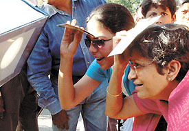 Some visitors have a look at the solar eclipse through a telescope at Nehru Planetarium in the Capital on Monday