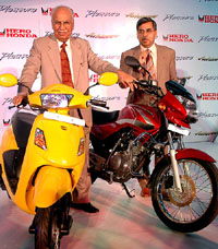 Chairman of Hero Honda Motors Ltd Brij Mohan Lall (left) poses with scooter Pleasure while Managing Director Pawan Munjal poses with motor cycle  Achieverin New Delhi on Wednesday.