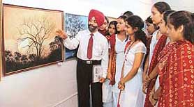 Art teacher Jaspreet Mohan Singh of Shaheed-e-Azam Sukhdev Thapar Government Senior Secondary School explains the intricacies of paintings to the students during an art exhibition held.