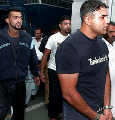 Britons of Pakistani origin Imran Shahid Zeeshan Shahid and Mohammad Fazal Mustaq are escorted by officials of the Federal Investigation Agency at Islamabad airport for deportation on Wednesday