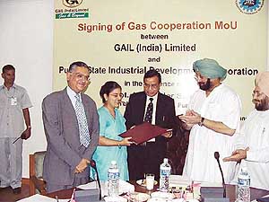 Mrs Ravneet Kaur, MD, PSIDC, exchanges documents with Dr U.D. Choubey, Director (Marketing), GAIL, just after signing an MoU in Chandigarh on Thursday as Punjab Chief Minister Amarinder Singh looks on.
