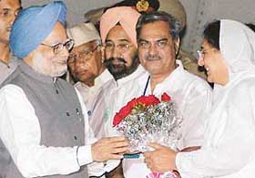 Ms Rajinder Kaur Bhattal, Deputy Chief Minister, Punjab, presents a bouquet to the Prime Minister, Dr Manmohan Singh, at the Chandigarh airport on Friday night. Mr Venod Sharma, Excise and Taxation Minister (second from right), is also seen.