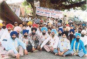 Employees of the Ranjit Sagar Dam sit on a dharna on Friday.