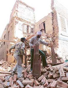 Rescue workers remove debris from a damaged house following a powerful earthquake at Sattowal market in Amritsar