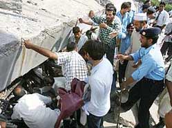 Volunteers search for trapped residents as a housing complex collapsed after a severe earthquake hit Islamabad on Saturday.