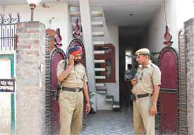 Cops outside the house where a woman and her son were found murdered in Ludhiana on Sunday