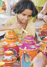Priyanka paints the top of a clay creation in Ludhiana