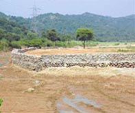 Construction activity in progress on a chunk of land, protected under the forest protection laws, near Perch village; A retaining wall has been raised in a seasonal rivulet, Patiali ki Rao, at Karoran village. The activity is in violation of the Forest Conservation Act.