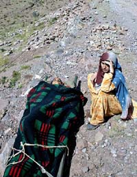 A Kashmiri woman sits besides a wounded woman in Sultandaki, 128 km west of Srinagar, on Tuesday