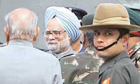 Prime Minister Manmohan Singh talks to Kashmir Governor S.K. Sinha in Srinagar after visiting the quake-hit areas of Jammu and Kashmir on Tuesday