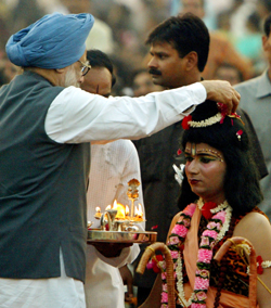 Prime Minister Manmohan Singh places rose petals on an artiste dressed as Lord Rama during the Dasehra festival celebrations in New Delhi on Wednesday