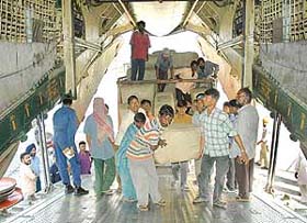 Workers load relief supplies in an IAF aircraft to be ferried to Srinagar at the Adampur Air Force Station near Jalandhar